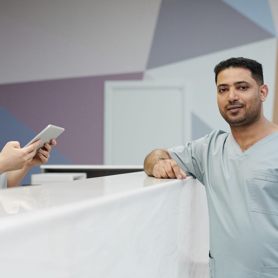 Clinic staff in scrubs at the front desk