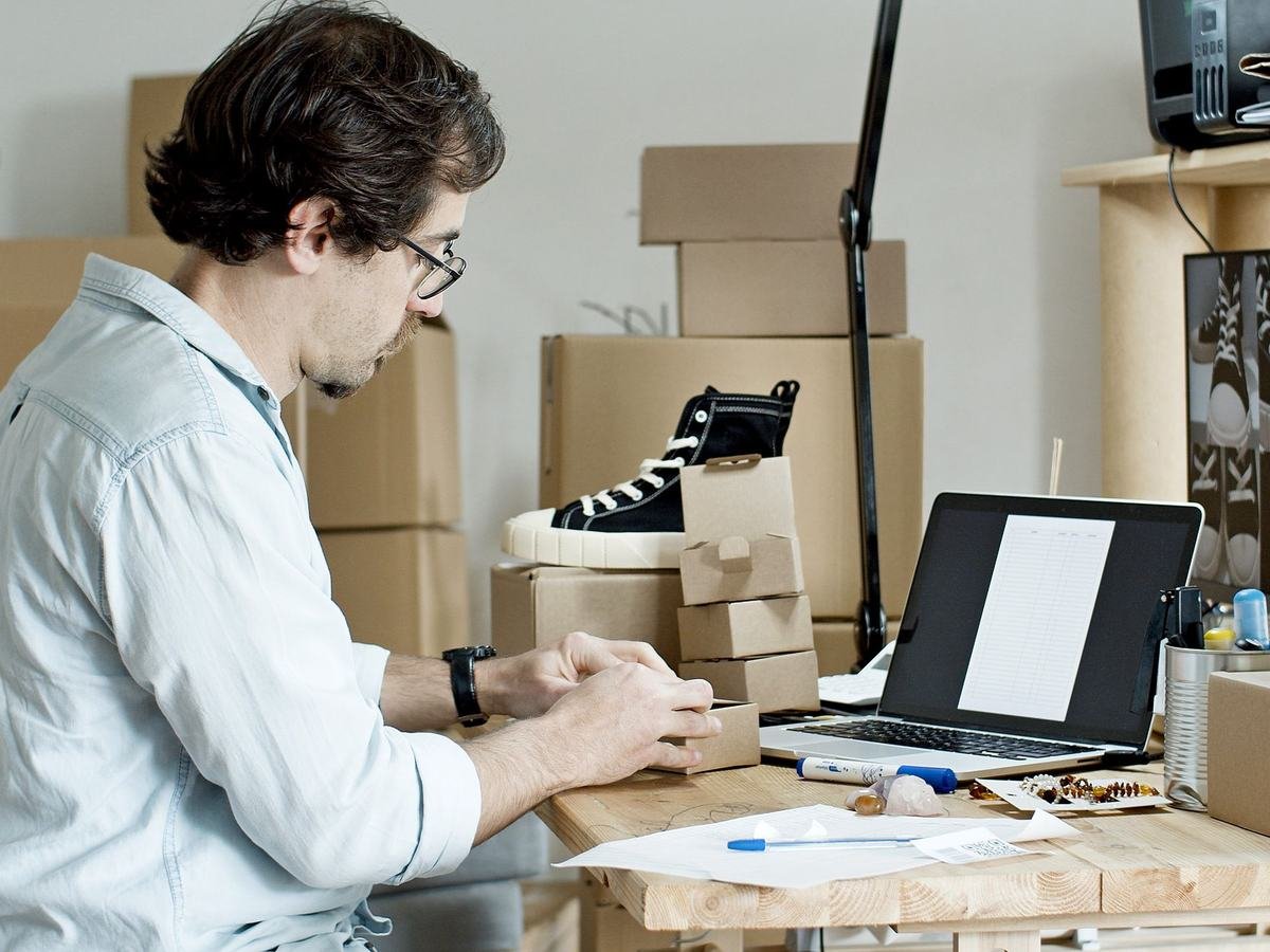 Pakistan mein chhote business ka malik courier ke liye online orders pack kar raha hai